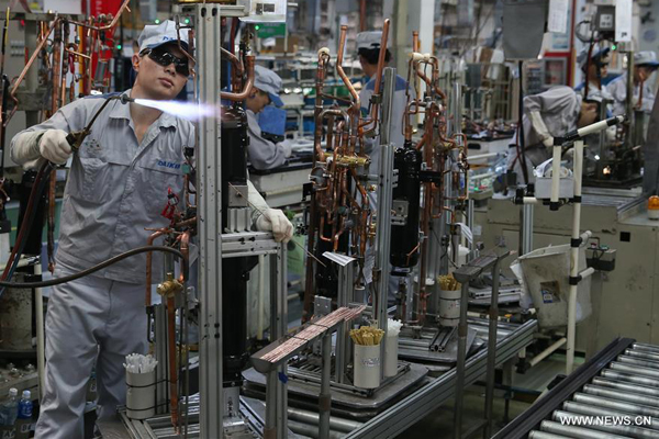 Workers are occupied on a production line at a factory in Xinzhuang industry zone in Shanghai, east China, July 30, 2015. China's economy grew by 6.9 percent in 2015. [Photo / Xinhua] 