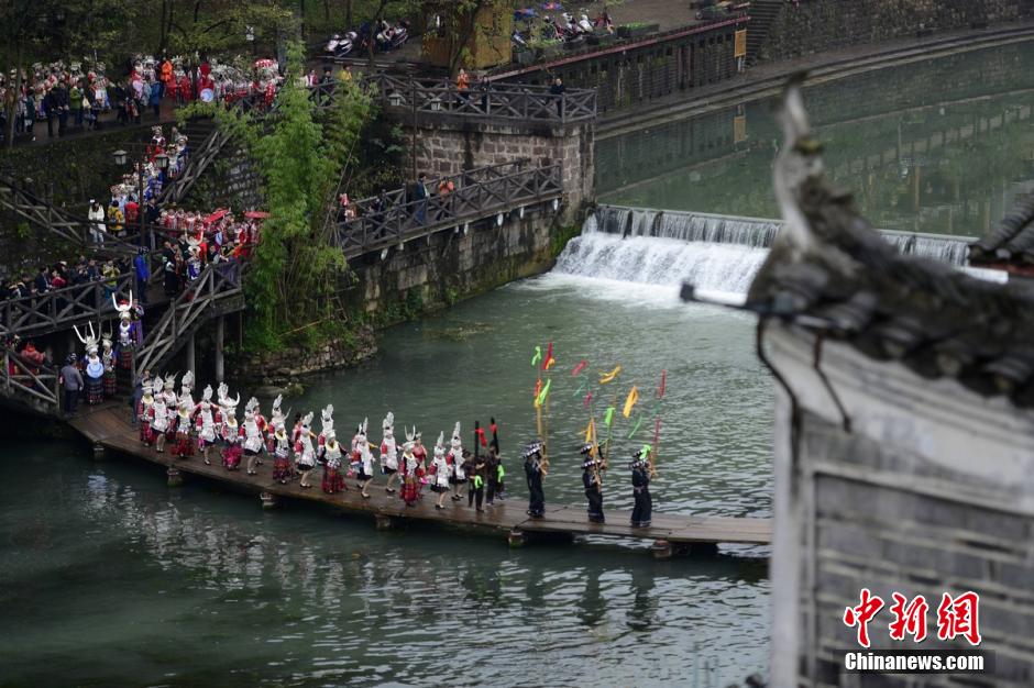 More than 100 Miao women dressed up in glamorous local costumes travel around the ancient town of Fenghuang in the west part of Hunan province on December 2nd, 2015. The show is part of the 5th China Fenghuang Miao Ethnic Silver-wear and Costumes Festival. [Photo: Chinanews.com]