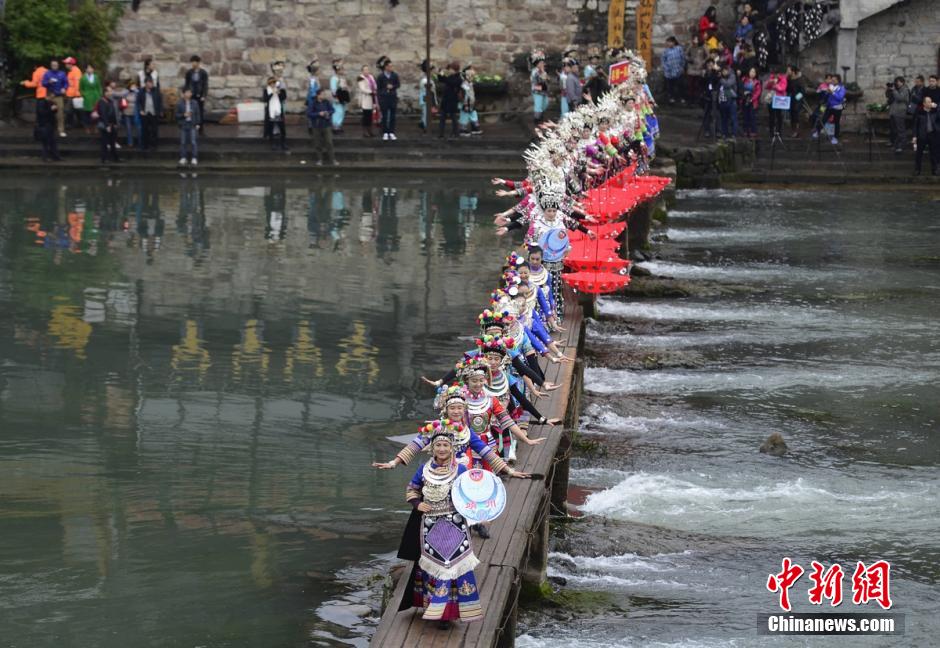 More than 100 Miao women dressed up in glamorous local costumes travel around the ancient town of Fenghuang in the west part of Hunan province on December 2nd, 2015. The show is part of the 5th China Fenghuang Miao Ethnic Silver-wear and Costumes Festival. [Photo: Chinanews.com]