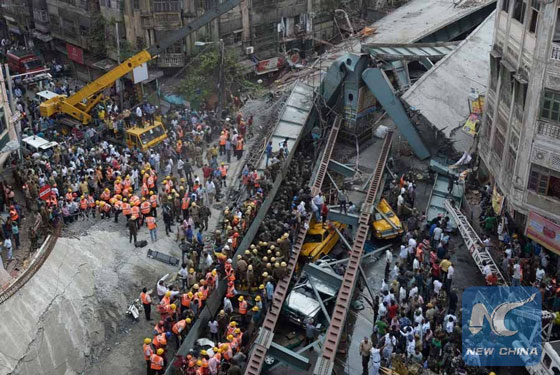 Indian rescue workers and volunteers try to free people trapped under the wreckage of a collapsed fly-over bridge in Kolkata, capital of eastern Indian state West Bengal, March 31, 2016. [Photo/Xinhua]