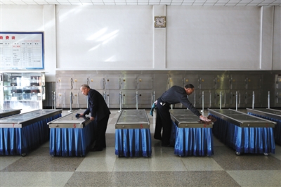 Two staff members are cleaning the cold cabinets in a funeral parlor in Beijing's eastern Tongzhou District.[Photo/Beijing News]