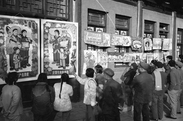 People view an exhibition of posters on the country's one-child policy in the 1980s. [Photo/Xinhua]