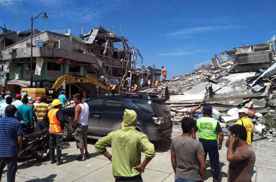 Residents stand in front of the debris of houses after an earthquake in the city of Chone, Manabi Province, Ecuador, on April 17, 2016. [Photo/Xinhua]