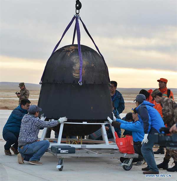 Scientific personnel work at the landing area of the re-entry capsule of China's first retrievable microgravity satellite SJ-10 in Siziwang Banner, North China's Inner Mongolia autonomous region, April 18, 2016.[Photo/Xinhua] 