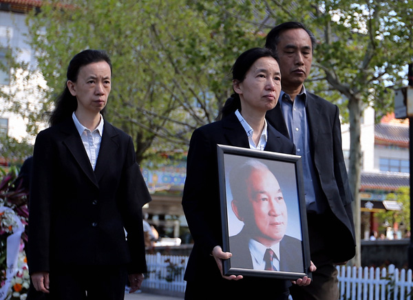 Liang Hong (center), daughter of Liang Sili, holds a portrait of her father at his funeral at Babaoshan Revolutionary Cemetery, the main resting place for highranking revolutionary heroes and government officials, in Beijing on April 18, 2016. Liang, 91, died on April 14 from an undisclosed illness. [Photo by Wang Zhuangfei/China Daily]