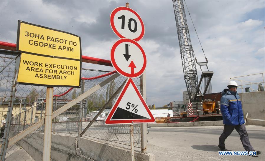 A worker passes by construction signs in the Chernobyl nuclear power plant, Ukraine, on April 22, 2016. Chernobyl, a place replete with horrific memories in northern Ukraine, close to Belarus, is now open to tourists, almost 30 years to the date after a nuclear power plant there exploded. [Photo/Xinhua]