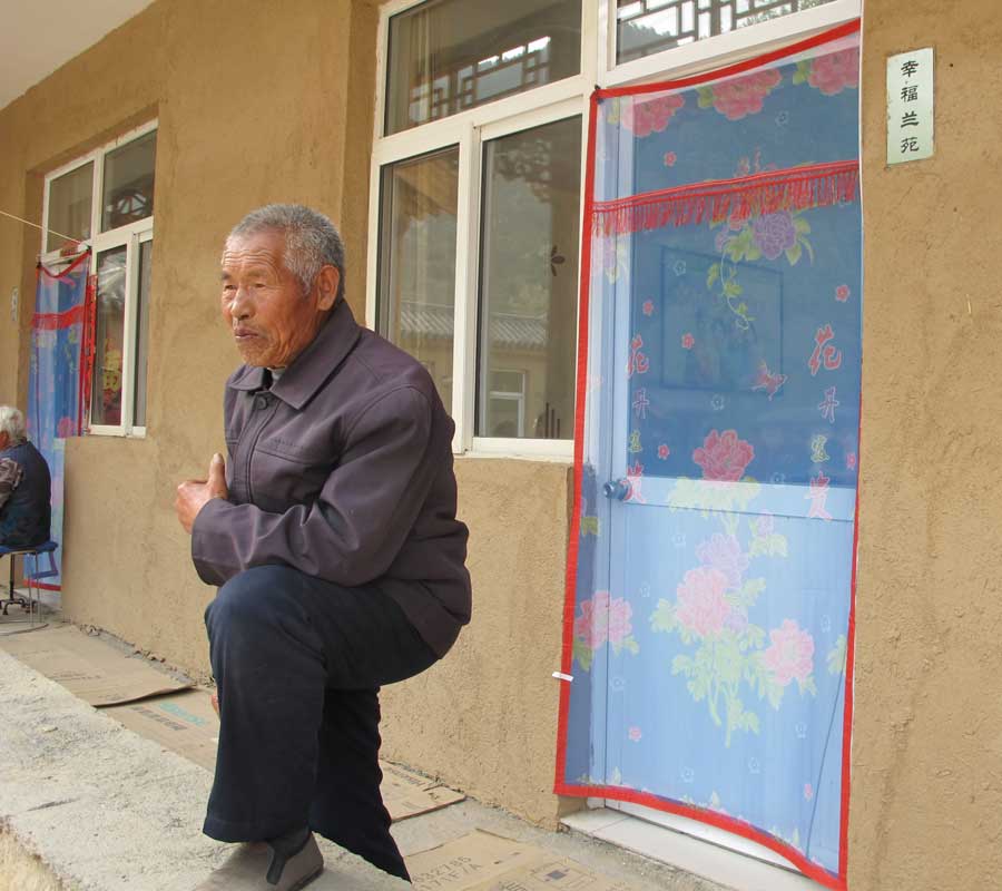 A man stands in front of the newly built nursing home. [Photo by Wu Yan/chinadaily.com.cn] 