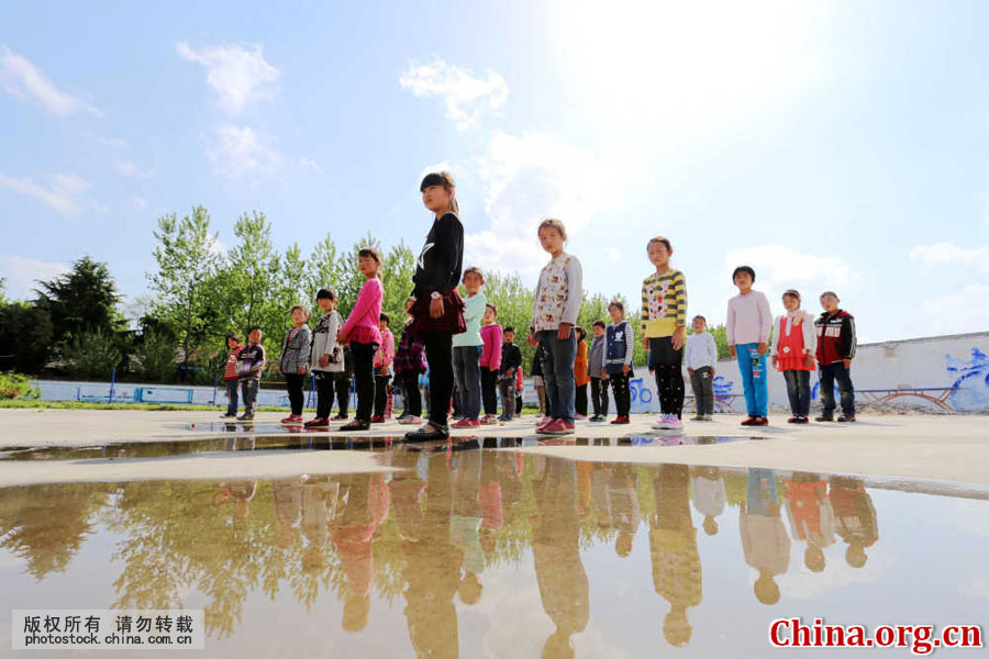 Students attend the national flag-raising ceremony at Gongping Primary School located in Goudong Village in Renqiao Town of Bengbu City, Anhui Province, on April 18, 2016. [Photo by Li Bin/China.com.cn]