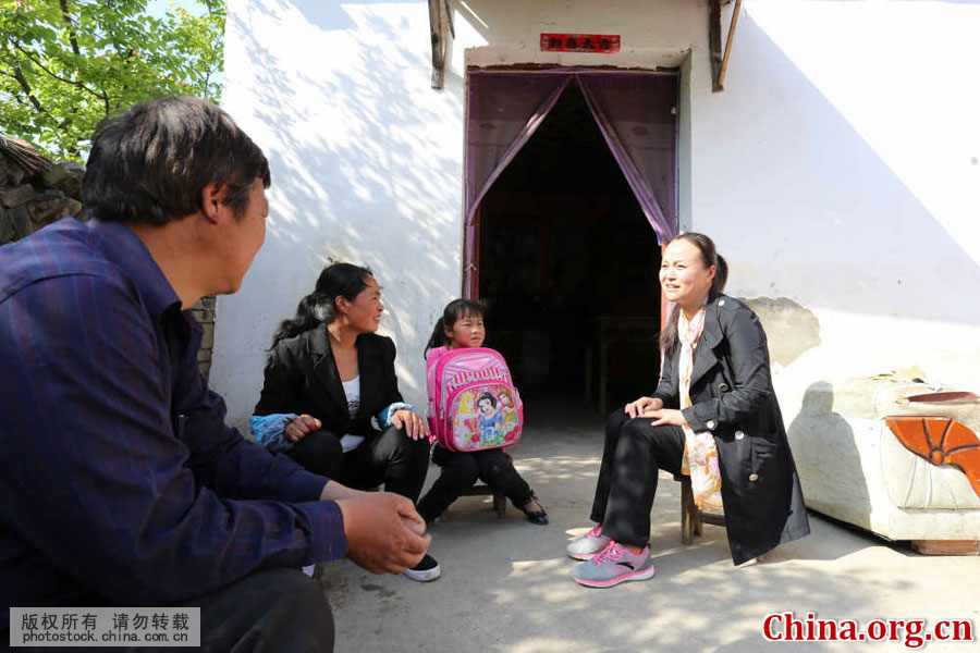 Wu Songyan visits her student Kong Yuqing's home in Goudong Village in Renqiao Town of Bengbu City, Anhui Province, on April 18, 2016. The 10-year-old girl has been left behind by her mother. Her father is busy with farming, so she helps take care of her younger brother and sister after school. [Photo by Li Bin/China.com.cn]