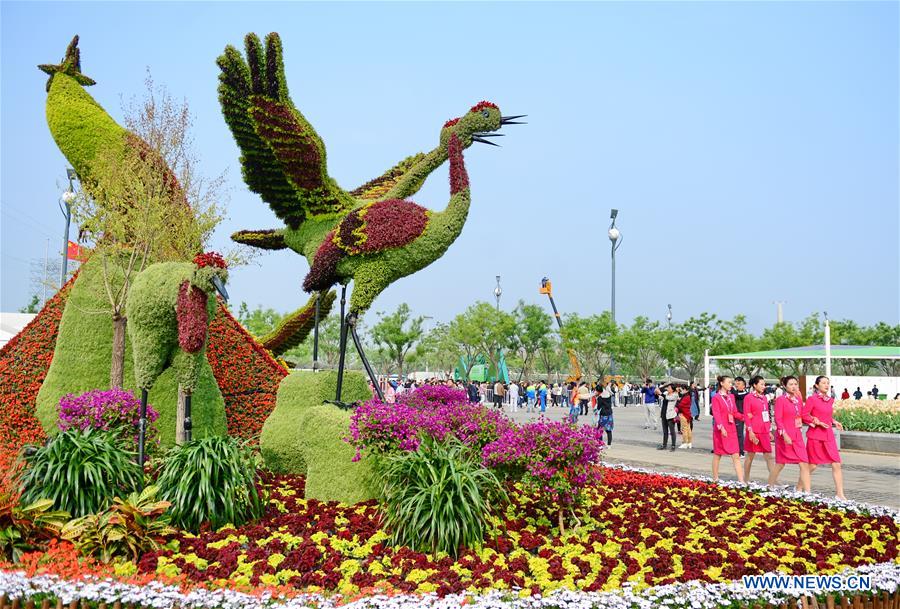 Staff members walk past a square of the Tangshan International Horticultural Exposition 2016 in Tangshan City, north China's Hebei Province, April 29, 2016. The Tangshan International Horticultural Exposition 2016 opened here on Friday and will last for 171 days. [Xinhua]