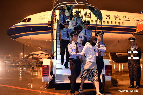 Chinese telecom fraud suspects are escorted off an aircraft by the police at Guangzhou Baiyun International Airport in Guangzhou, capital of south China's Guangdong Province, April 30, 2016.(Xinhua/Liang Xu)