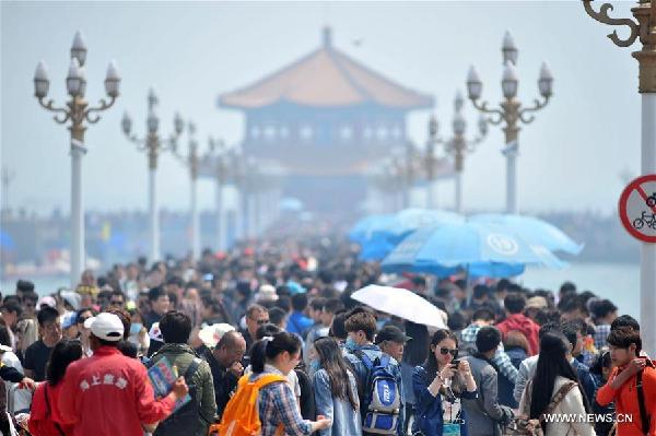 Tourists visit the Zhanqiao Pier in Qingdao, a coastal city in east China's Shandong Province, April 30, 2016. On the first day of the Labor Day Holiday, many tourists flocked to Qingdao. (Xinhua/Yin Mo)