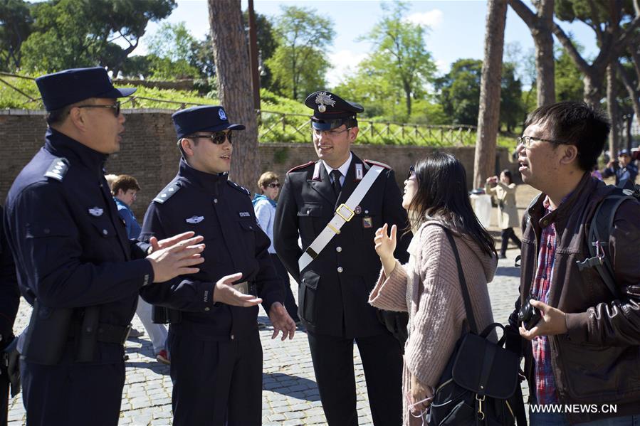 Chinese police Shu Jian (1st L) and Sa Yiming (2nd L) talk with two tourists from Beijing outside the Colosseum in Rome, Italy, May 2, 2016.