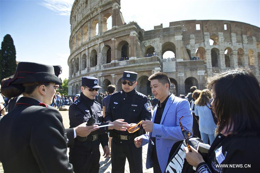 Chinese police Shu Jian (3rd R) and Sa Yiming (4th R) , together with two Italian police, check the documents of a Chinese tourist group outside the Colosseum in Rome, Italy, May 2, 2016.