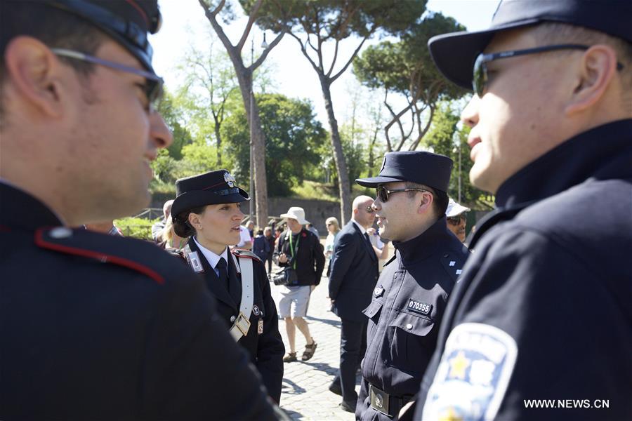 Chinese police Shu Jian (1st R) and Sa Yiming (2nd R) talk with two Italian police outside the Colosseum in Rome, Italy, May 2, 2016. 