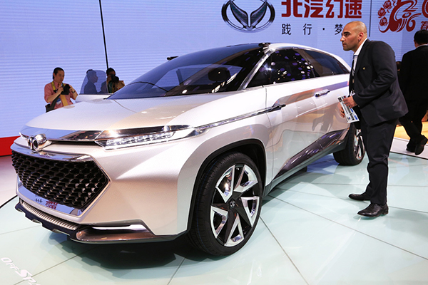 A visitor to the 2016 Beijing International Auto Expo, which was held last month, examines a new-energy vehicle made by Beijing Automotive Industry Holding Co. [Photo/Xinhua]