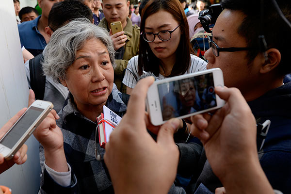 A woman identified only as Lu tells reporters at the Second Hospital of the Beijing Armed Police Corps in Beijing on Tuesday she is seeking are fund for therapy received by her husband, who had liver cancer and died in March last year. [Wei Xiaohao/China Daily] 