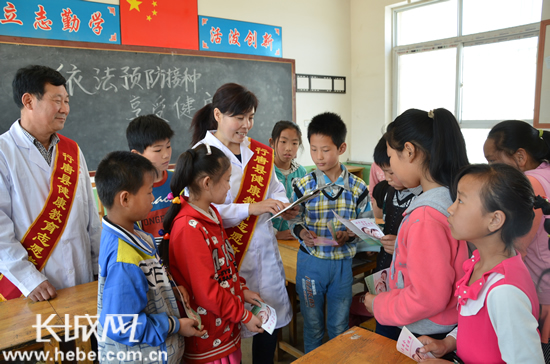 A photo taken on April 25, 2016 shows health workers introduce vaccination-related knowledge in a primary school in north China’s Hebei province. [Photo: hebei.com.cn] 