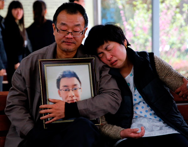The parents of Wei Zexi, a computer science major at Xidian University in Shaanxi province who died of a rare form of cancer, wait outside a funeral home in Xianyang, Shaanxi, on April 13. [Wan Jia/ for China Daily ]