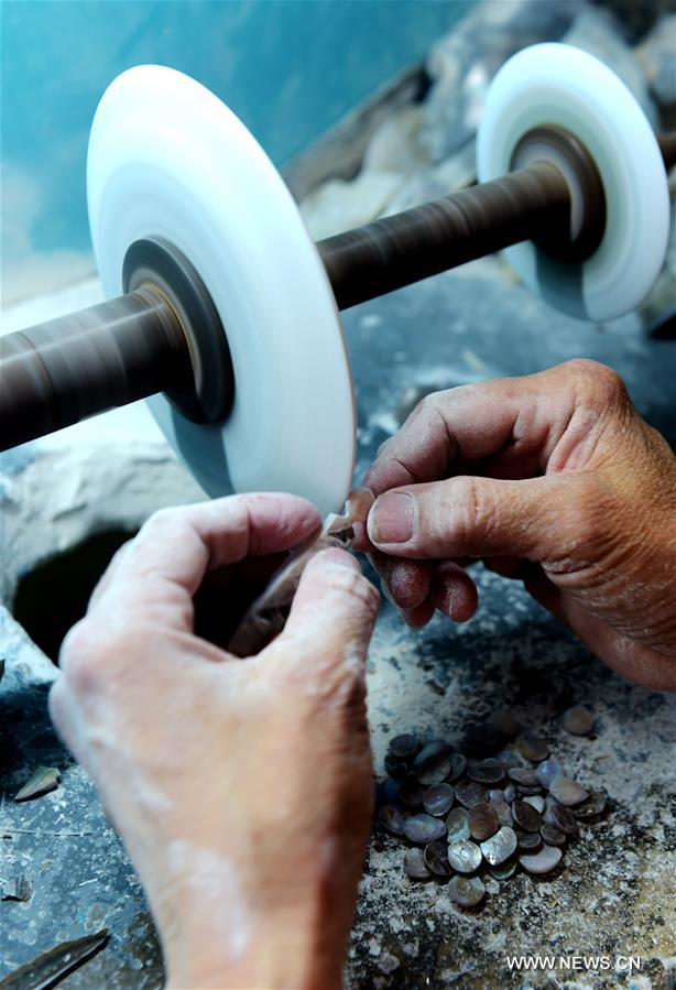 A staff worker carves shells at a museum in Beihai, south China's Guangxi Zhuang Autonomous Region, May 3, 2016. Local workers have used skills of Chinese painting and embroidery in the process of shell carving in recent years. [Xinhua]