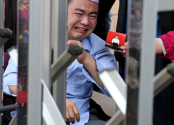 A patient weeps in front of the Second Hospital of the Beijing Armed Police Corps on Wednesday. [Wang Zhuangfei / China Daily] 