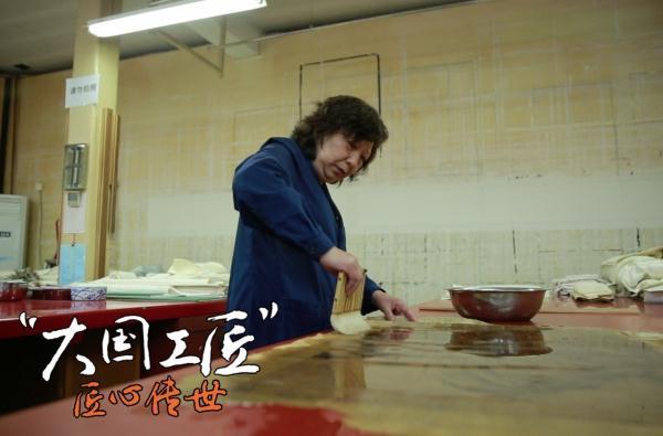 Shan Jiajiu restores a painting from Qing Dynasty. [A still image from China Central Television] 