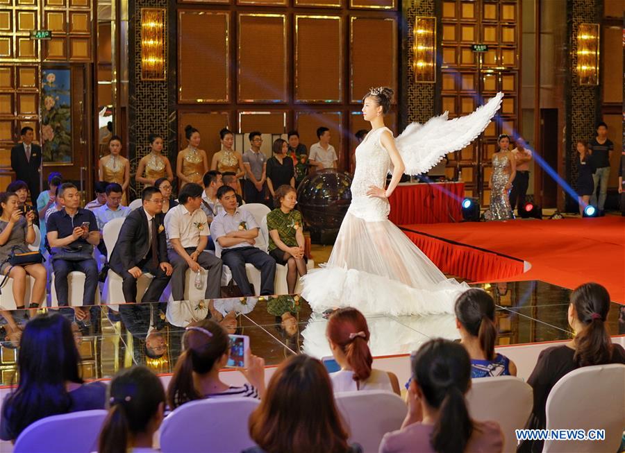 A pregnant woman takes part in a fashion show in Chongqing, southwest China, May 5, 2016. [Xinhua]