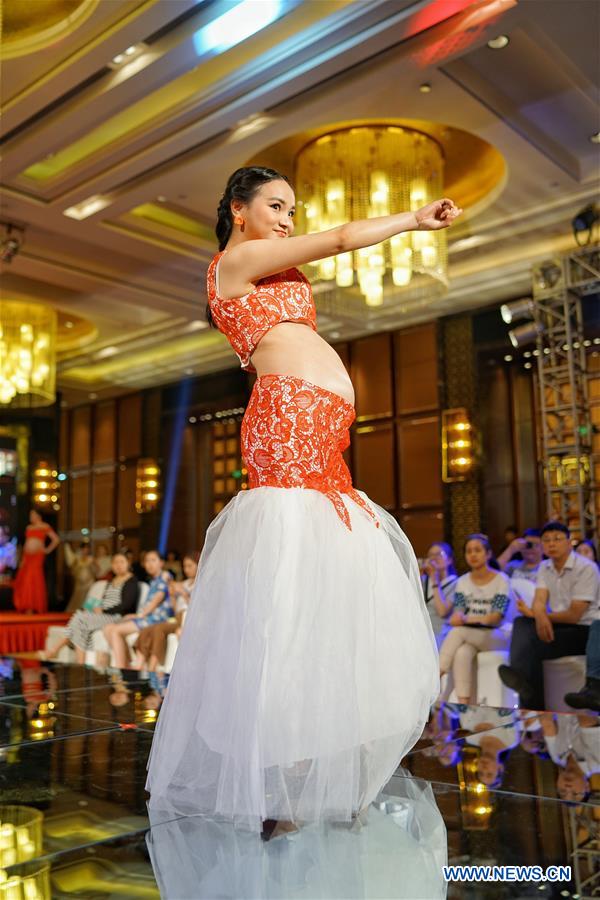 A pregnant woman takes part in a fashion show in Chongqing, southwest China, May 5, 2016. [Xinhua]