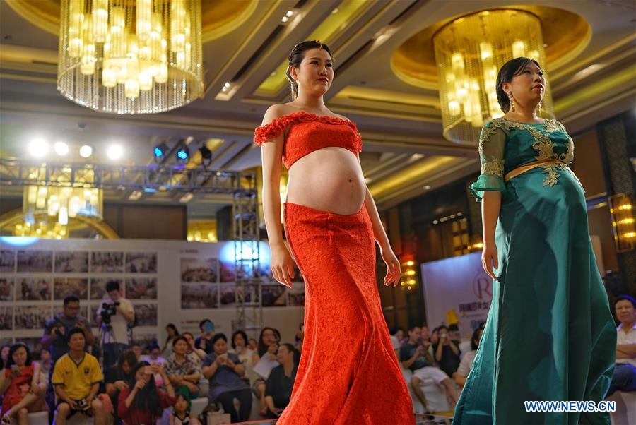 A pregnant woman takes part in a fashion show in Chongqing, southwest China, May 5, 2016. [Xinhua]