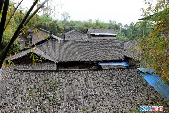 Bungalows stand behind the stone façade discovered in Guang’an, Sichuan Province. [Photo: Sichuan Online] 