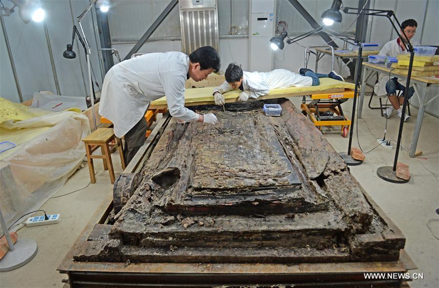 Archaeologists clean up the interior coffin of the 2,000-year-old tomb of Haihunhou, the Marquis of Haihun, in Nanchang, east China's Jiangxi Province, May 4, 2016. 