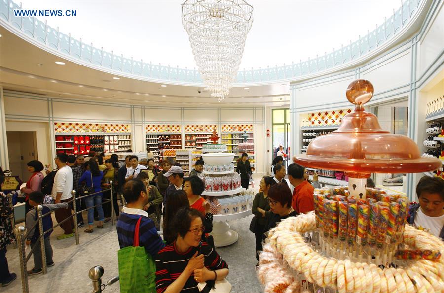 Tourists select goods at a dessert shop in the Disney Town of the Disney Resort in Shanghai, May 7, 2016. Two shops in the Disney Town opened here on Saturday, when the Shanghai Disneyland, Disney's first theme park in the Chinese mainland, started an operational test. [Xinhua] 