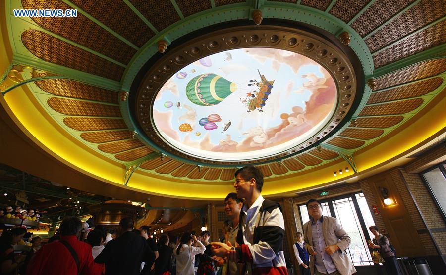 Tourists are seen at a souvenir shop in the Disney Town of the Disney Resort in Shanghai, May 7, 2016. Two shops in the Disney Town opened here on Saturday, when the Shanghai Disneyland, Disney's first theme park in the Chinese mainland, started an operational test. [Xinhua] 