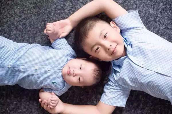 A boy with his younger brother. [Photo provided to chinadaily.com.cn] 