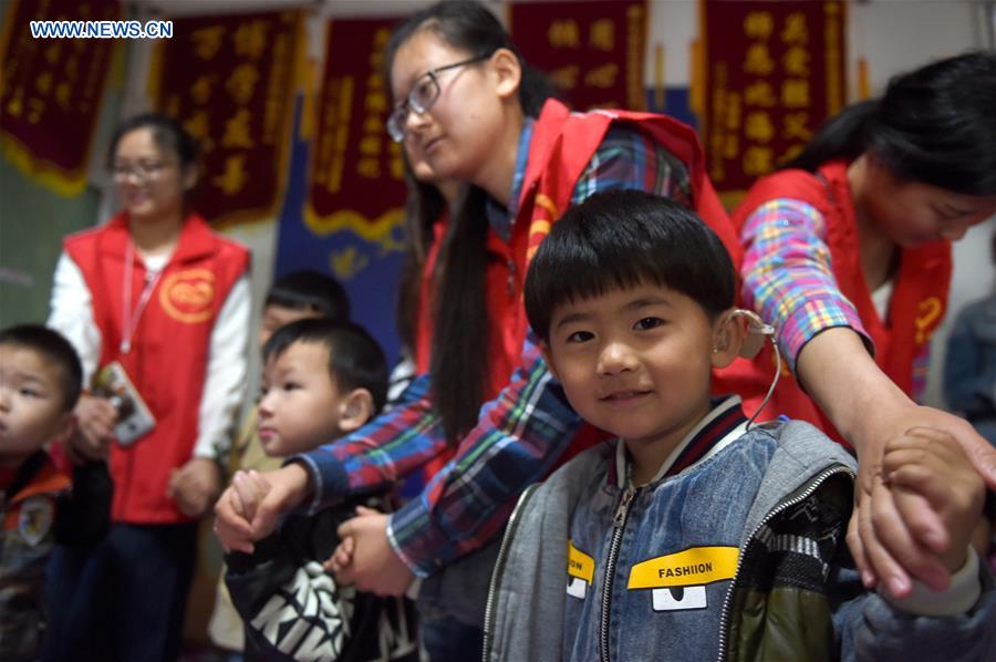 Volunteers play games with hearing impaired children in Hefei, east China's Anhui Province, on May 15, 2016, the National Day for Helping the Disabled, which is marked on the third Sunday of May every year. [Photo/Xinhua]