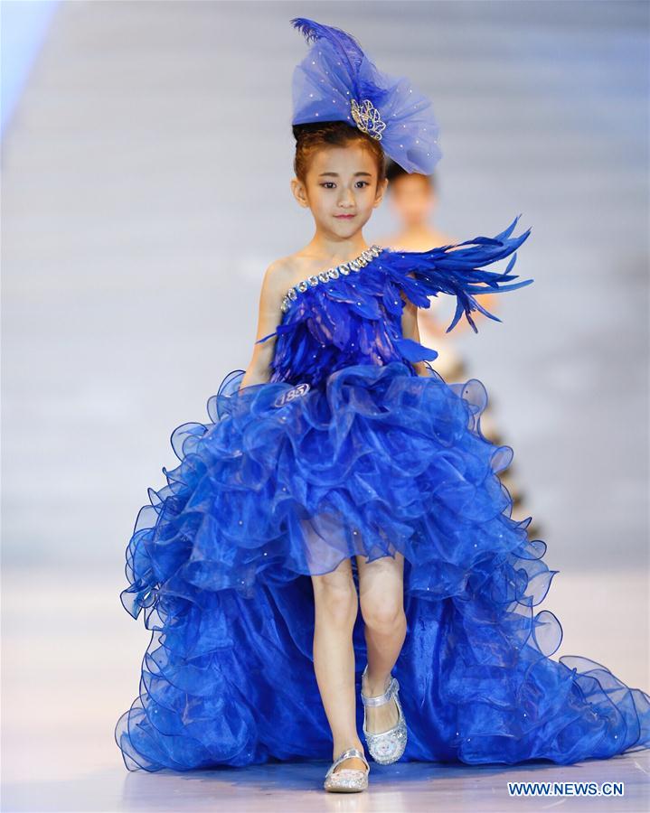 A participant presents a creation at a mini model contest during the 16th China (Qingdao) International Fashion Week in Qingdao, east China's Shandong Province, May 14, 2016. More than 200 children from all over the country took part in the contest. [Photo/Xinhua]