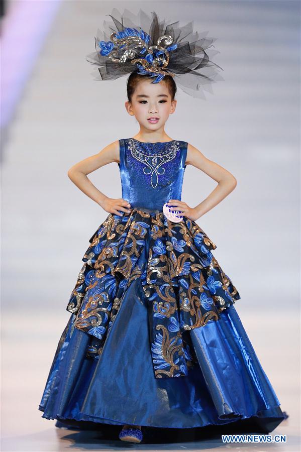 A participant presents a creation at a mini model contest during the 16th China (Qingdao) International Fashion Week in Qingdao, east China's Shandong Province, May 14, 2016. More than 200 children from all over the country took part in the contest. [Photo/Xinhua]