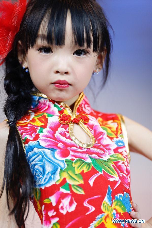 A participant presents a creation at a mini model contest during the 16th China (Qingdao) International Fashion Week in Qingdao, east China's Shandong Province, May 14, 2016. More than 200 children from all over the country took part in the contest. [Photo/Xinhua]