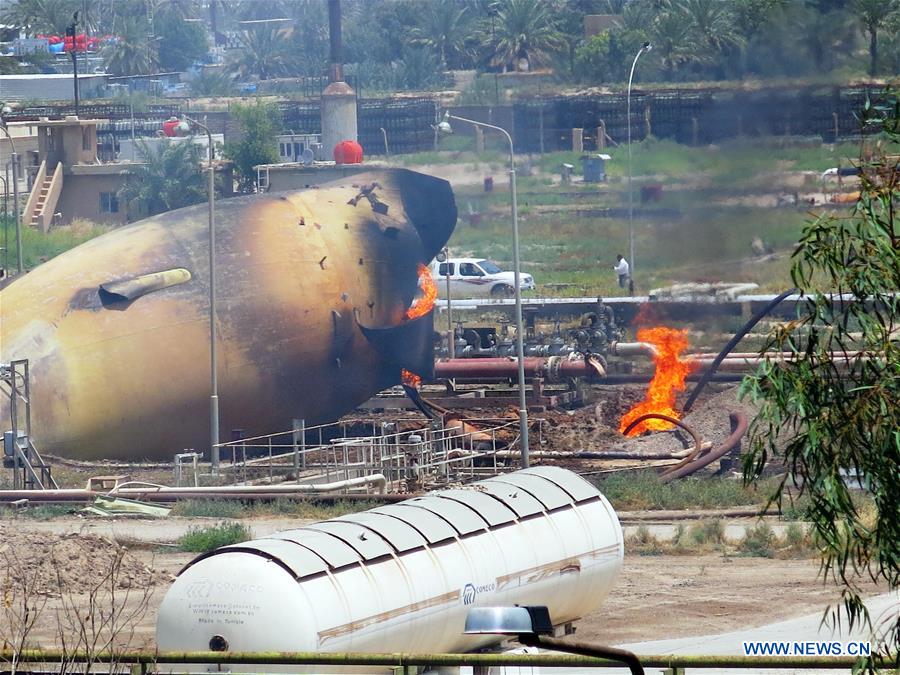 A storage gas tank is on fire at a gas plant after it was attacked by Islamic State (IS) suicide bombers, in Taji area, northern suburb of the Iraqi capital of Baghdad, May 15, 2016. Up to seven security members and civilian workers were killed and 24 others wounded on Sunday, as Iraqi security forces foiled an attempt by Islamic State (IS) suicide bombers to seize and destroy a gas plant in a northern suburb of Baghdad, an Interior Ministry source said. [Photo/Xinhua]