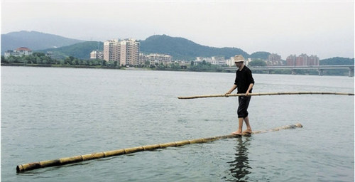 Fang Shuyun crosses the Fuchun River on a bamboo stick. [Zhejiang Online]