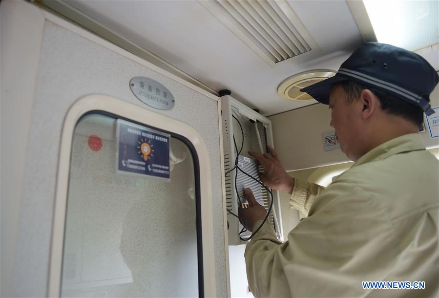 A worker installs WiFi device on a train administrated by the railway bureau of Chengdu, capital of southwest China&apos;s Sichuan Province, May 20, 2016. This year WiFi would be installed on 100 non-high-speed trains run by Chengdu railway bureau in order to enrich the experience of passengers. (Xinhua/Xue Yubin) 