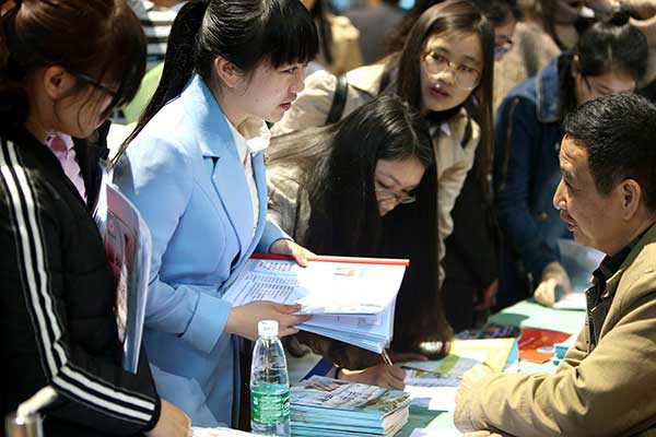 Graduates from normal universities in Hunan province interact with their potential employers at a job fair in Hengyang in March. More than 4,000 graduates participated in the event.[Peng Bin/For China Daily]  