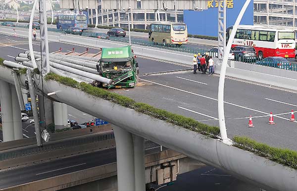 An overloaded truck overturns on the Middle Ring Road in Shanghai's Baoshan district on early Monday morning. [Photo/China Daily] 