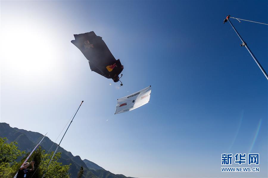 American professional skydiver and base-jumper Jeb Clissor successfully performs the “Human Arrow” stunt at the Great Wall in north China’s Tianjin, May 29, 2016. [Photo: Xinhua/Bai Yu]