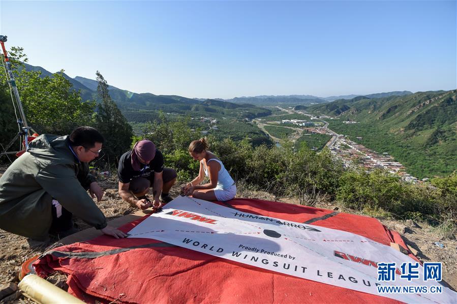 American professional skydiver and base-jumper Jeb Clissor successfully performs the “Human Arrow” stunt at the Great Wall in north China’s Tianjin, May 29, 2016. [Photo: Xinhua/Bai Yu] 