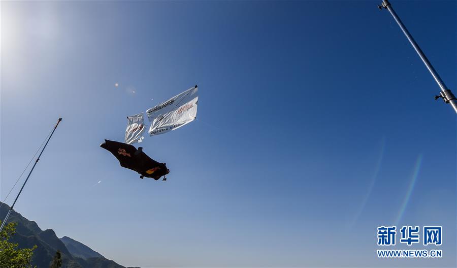 American professional skydiver and base-jumper Jeb Clissor successfully performs the “Human Arrow” stunt at the Great Wall in north China’s Tianjin, May 29, 2016. [Photo: Xinhua/Bai Yu]