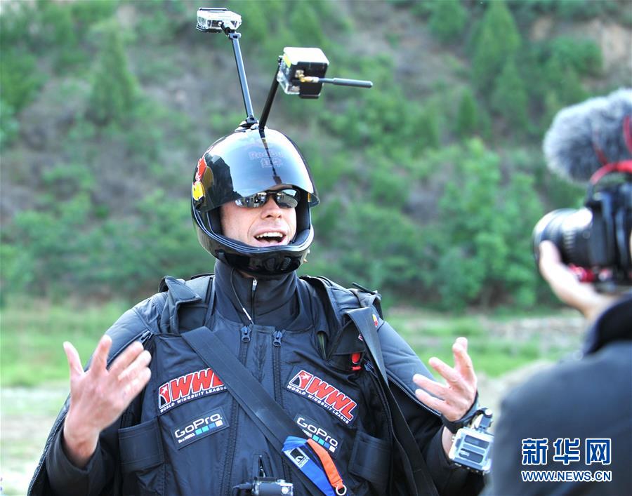 American professional skydiver and base-jumper Jeb Clissor successfully performs the “Human Arrow” stunt at the Great Wall in north China’s Tianjin, May 29, 2016. [Photo: Xinhua/Bai Yu]