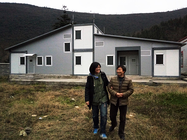 Liu and a teacher in front of a Flying Box dormitory in the school. Provided to CHINA DAILY