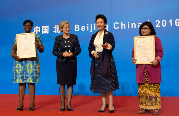 Peng Liyuan, China's first lady and a UNESCO special envoy (second from right), and director-general of UNESCO Irina Bokova (second from left) present awards at a ceremony in Beijing on Monday to winners of the first UNESCO Prize for Girl's and Women's Education. [Photo/China Daily]