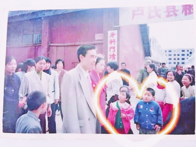 Newly-weds Wang Ming (boy in blue) and Zhu Haiyan (girl in pink) appear in the same photo taken 20 years ago. [Photo/dahe.cn] 